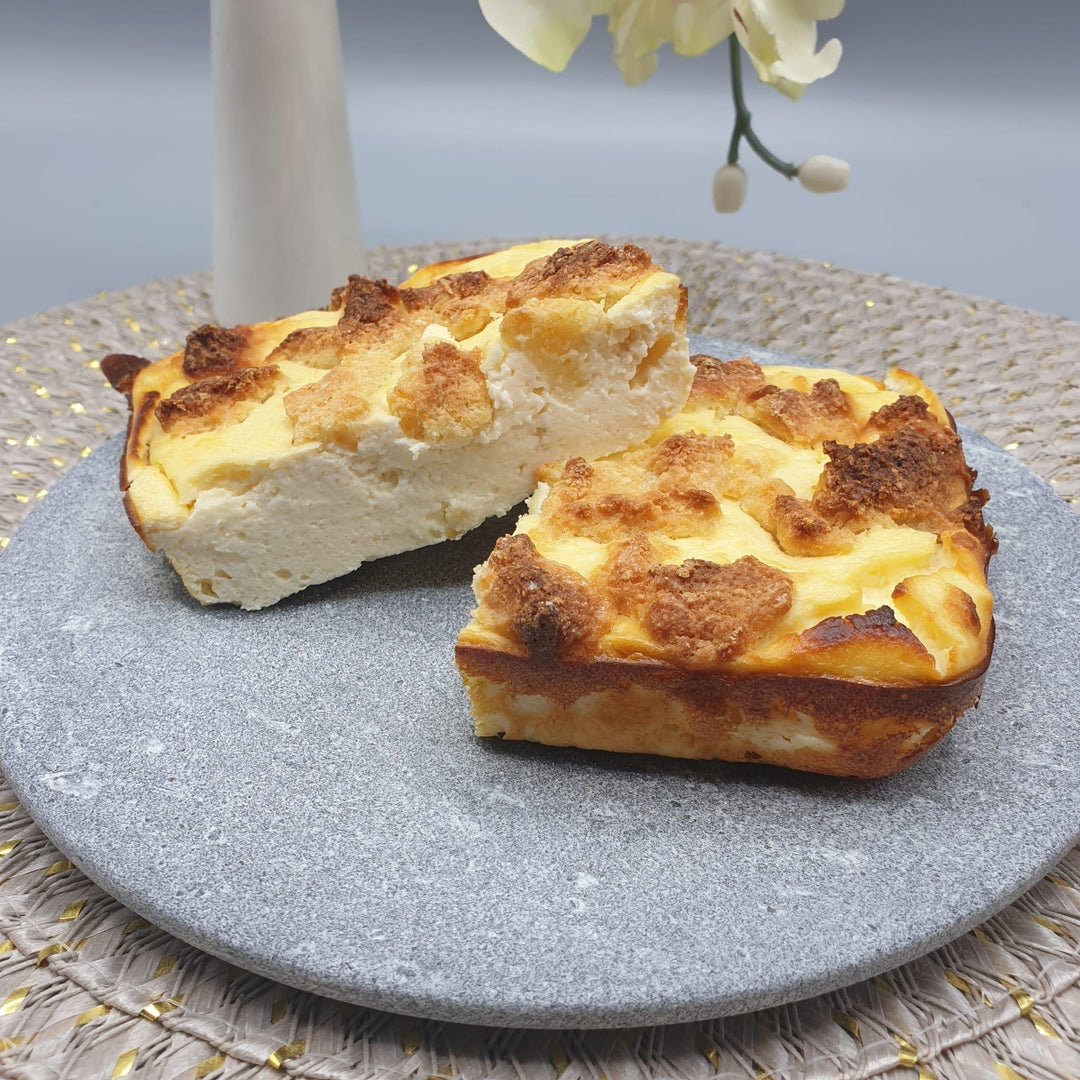 Einen grauen Teller aus Naturstein, karelischer Steatit aus Skandinavien, auf dem Quark-Käsekuchen präsentiert wird.