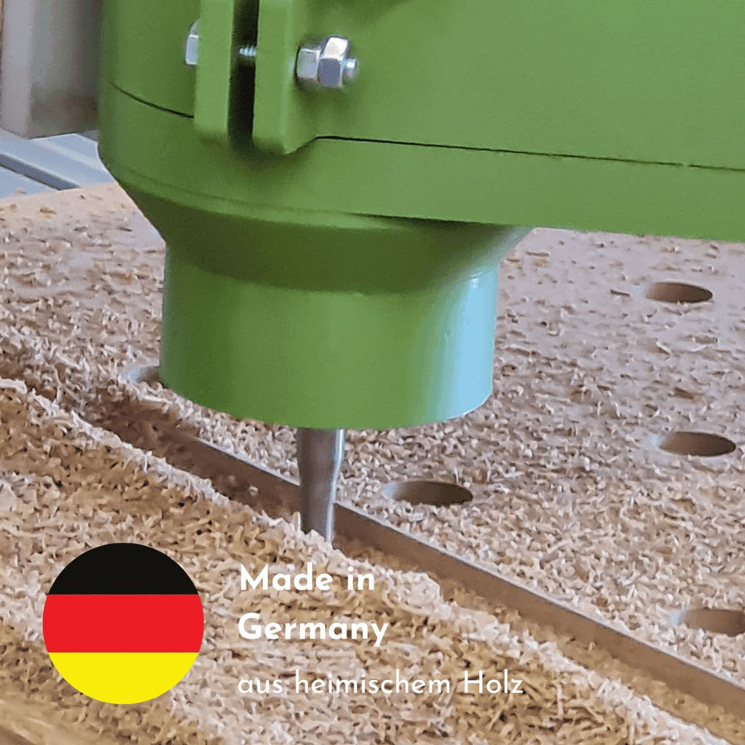 Ein Fräser fräst Altholz und es liegen Sägespäne auf der Arbeitsfläche. Eine deutsche Fahne erklärt, dass die Herstellung des Produkts in Deutschland stattfindet und es aus heimischem Holz  produziert wird.