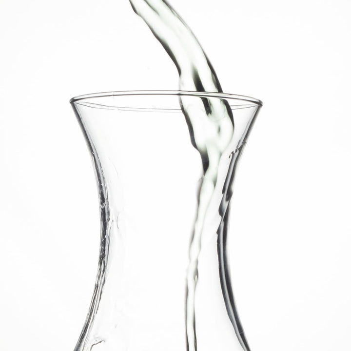 Detailansicht wie Wasser wird in eine Glaskaraffe gegossen