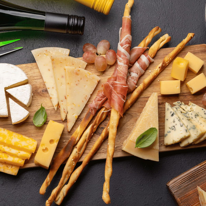 Servierbrett aus Altholz - Juvahem Lecker angerichtete Snacks, wie Käse, Schinken und Knuspersticks  auf einem Holzbrett - Draufsicht