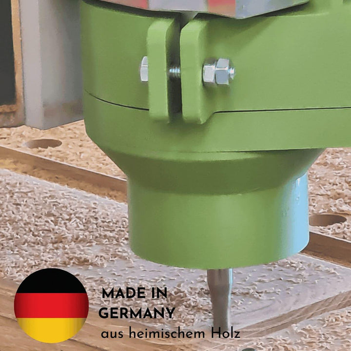 Ein Fräser fräst Altholz und es liegen Sägespäne auf der Arbeitsfläche. Eine deutsche Fahne erklärt, dass die Herstellung des Produkts Lowtray in Deutschland stattfindet und es aus heimischem Holz  produziert wird.