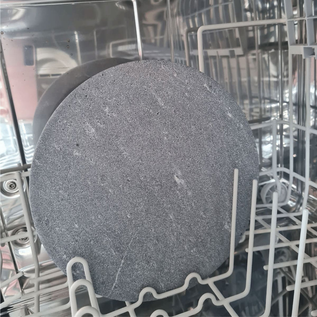 Ein Teller aus Naturstein steht in der Spülmaschine und zeigt damit, dass man die Natursteinprodukte bedenkenlos in der Geschirrspülmaschine reinigen kann.