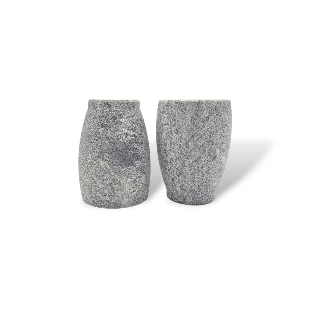 Zwei kleine graue Schnapsgläser aus Naturstein, karelischer Steatit aus Skandinavien, aus denen man besonders gut klaren, kalten Schnaps trinken kann. Ein Glas steht auf dem Kopf.
